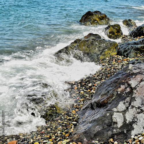 Beautiful seashore with water washing beautiful stones and color pebbles. Beauty of nature photo