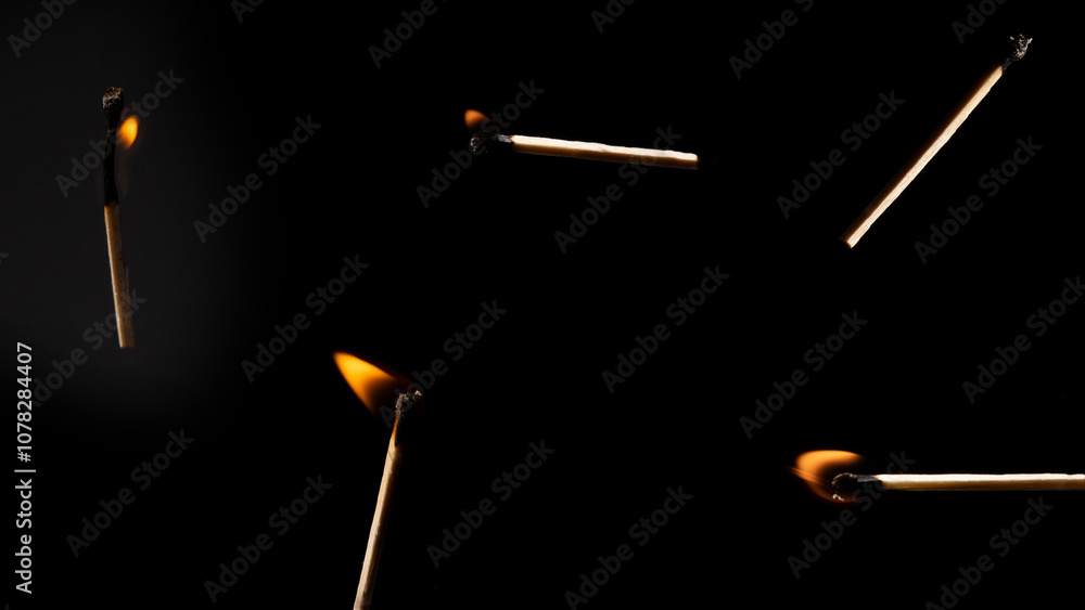 Lit falling match on a black background.