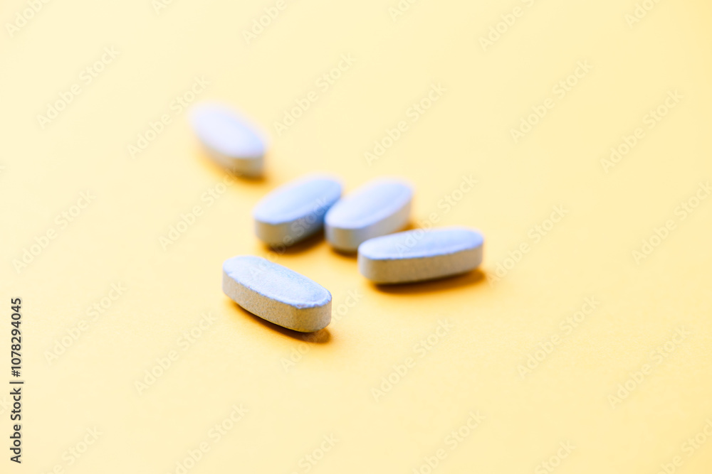 Multivitamin tablets on bright paper background. Close up. Copy space. Multivitamin tablets on bright paper background. Close up. Copy space.