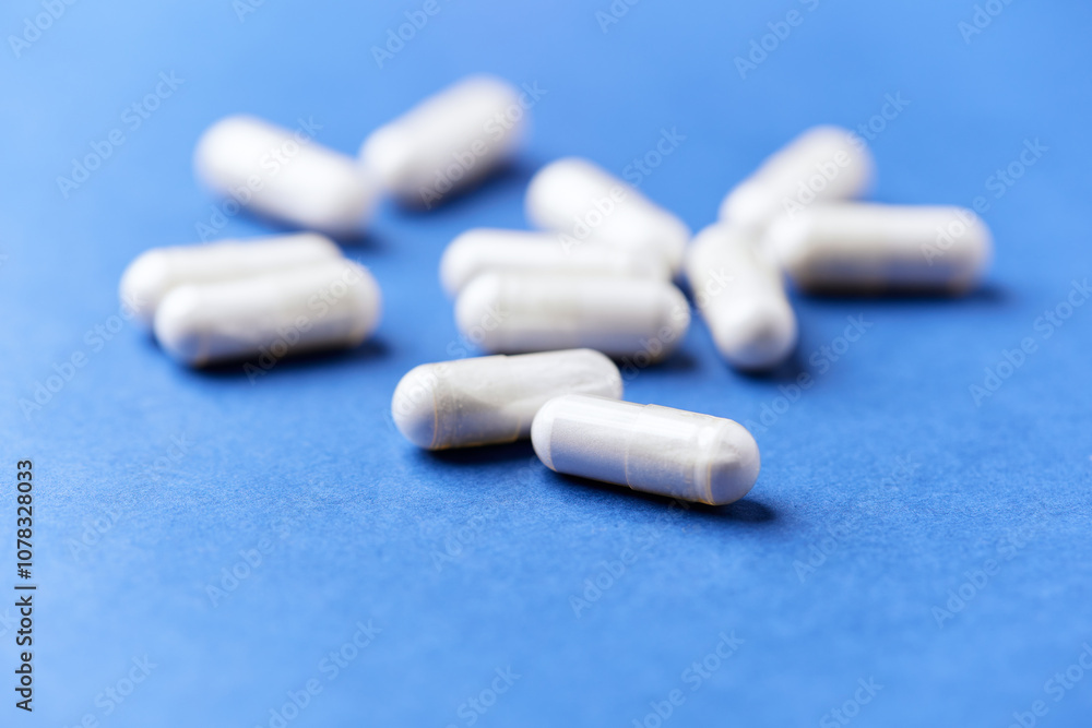 Tyrosine capsules (one of the 20 standard amino acids). A dietary supplement used to improve attention and focus on paper background. Soft focus. Close up. Tyrosine capsules (one of the 20 standard amino acids). A dietary supplement used to improve attention and focus on paper background. Soft focus. Close up.