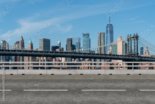 Empty road with view of Manhattan Bridge and New York City skyline in the background.