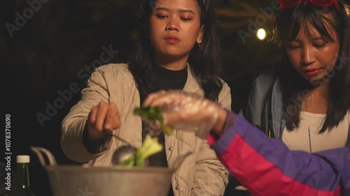 Group Of Multiethnic Asian College Students In Fancy Glasses Cooking And Eating At Campsite photo