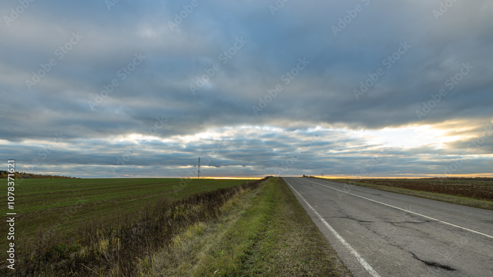 Fototapeta premium A road with a cloudy sky in the background