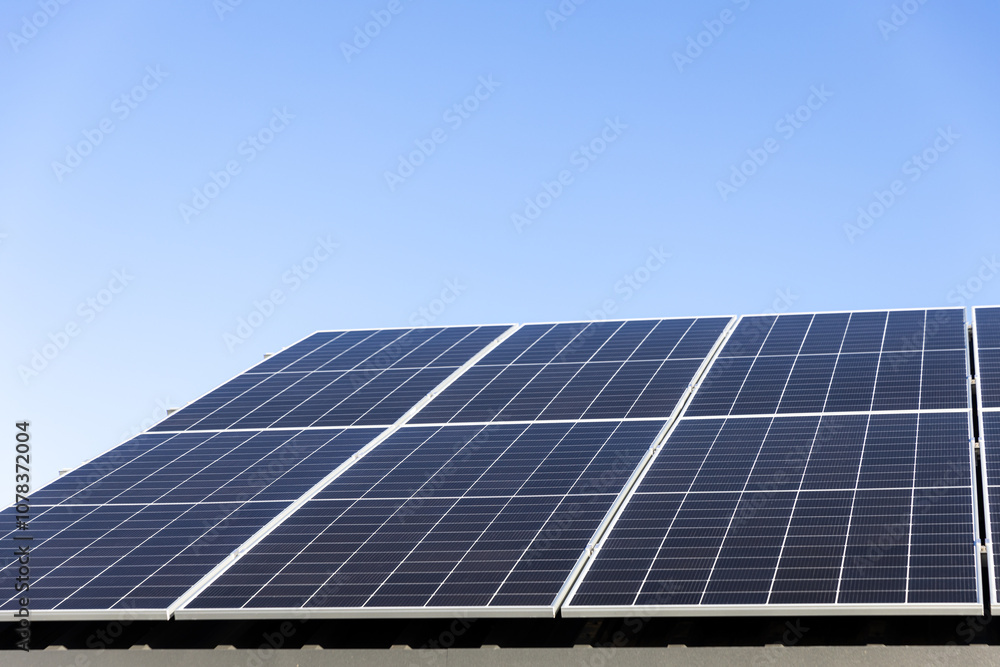 Aerial view of solar panel cells on clear blue sky background. Clean alternative energy power concept, sustainable resources. Modern house, solar panels stand-alone photovoltaic plant system on roof Aerial view of solar panel cells on clear blue sky background. Clean alternative energy power concept, sustainable resources. Modern house, solar panels stand-alone photovoltaic plant system on roof