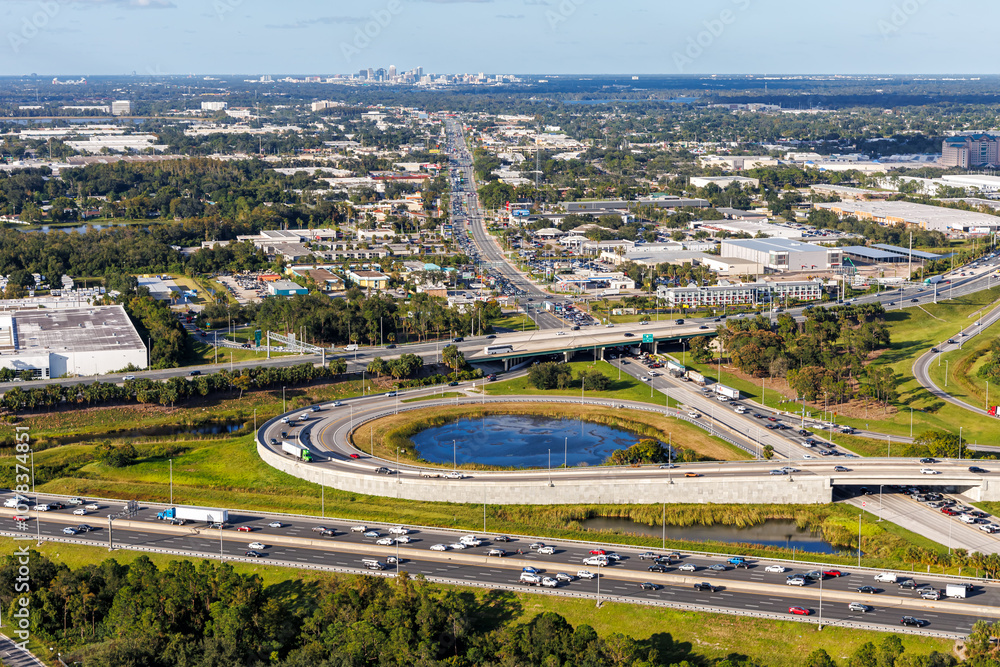 Aerial view on interstate crossing with Floridas Turnpike and Martin Andersen Beachline Expy with downtown in the background in Orlando, United States