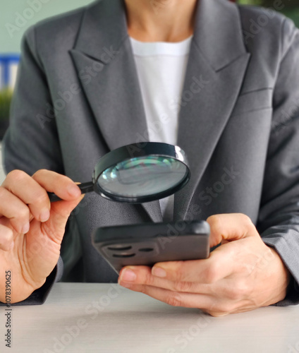 Businesswoman using smartphone with magnifying glass. Search online vertical concept photo