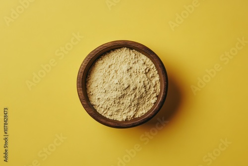 Collagen powder in a bowl against a yellow backdrop photo