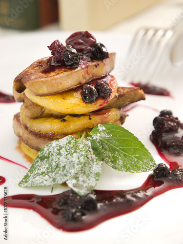 Gourmet foie gras made of the liver of a duck or goose served with baked pear and berries syrup