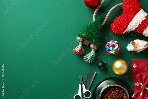 Pet supplies and toys on a green background, featuring a striped pet bone, Christmas tree ball, rope toy, clippers, comb, and pet food bowl. Ideal for holiday pet care themes photo