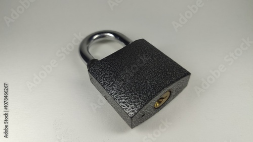 The photo shows a metal padlock. Lock it with a key.