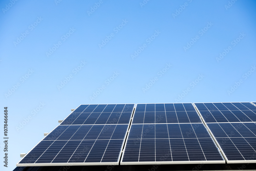 Aerial view of solar panel cells on clear blue sky background. Clean alternative energy power concept, sustainable resources. Modern house, solar panels stand-alone photovoltaic plant system on roof Aerial view of solar panel cells on clear blue sky background. Clean alternative energy power concept, sustainable resources. Modern house, solar panels stand-alone photovoltaic plant system on roof