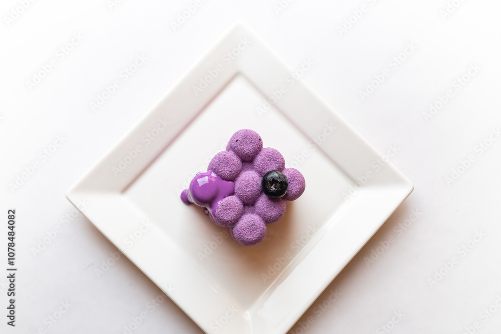 French mousse cake covered with violet glaze, shape of cube