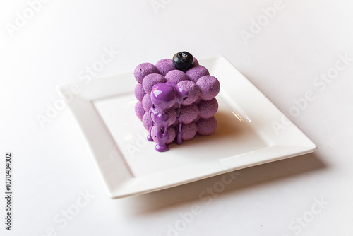 French mousse cake covered with violet glaze, shape of cube