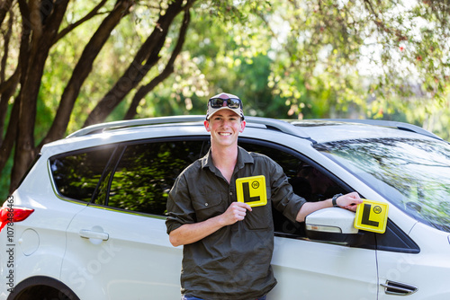 Aussie teen driver with l plate standing by car smiling photo