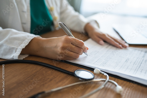 side side view of doctor signature on clipboard near laptop on desk