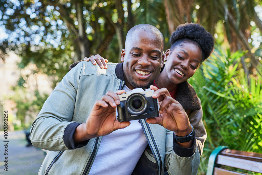 Smiling Couple Enjoying a Day in the City While Looking at Photos on a Digital Camera in a Sunny Park Smiling Couple Enjoying a Day in the City While Looking at Photos on a Digital Camera in a Sunny Park