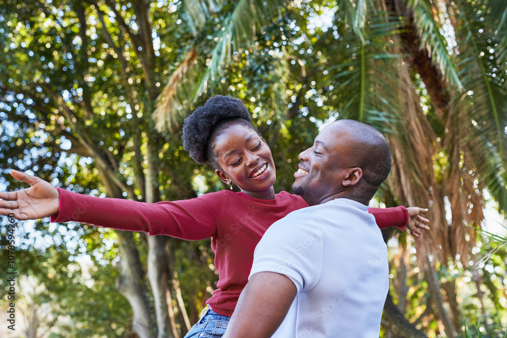 Joyful Couple Embracing in a Sunlit Park Under Tropical Trees in the City Joyful Couple Embracing in a Sunlit Park Under Tropical Trees in the City