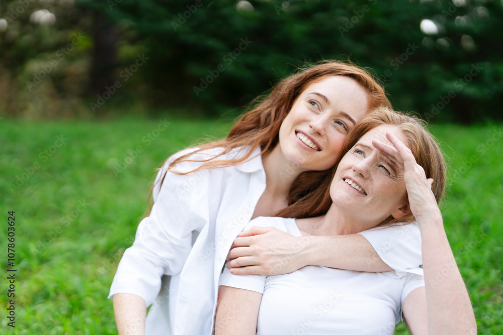 Two women enjoying a sunny day in the park while spending quality time together and sharing laughter Two women enjoying a sunny day in the park while spending quality time together and sharing laughter