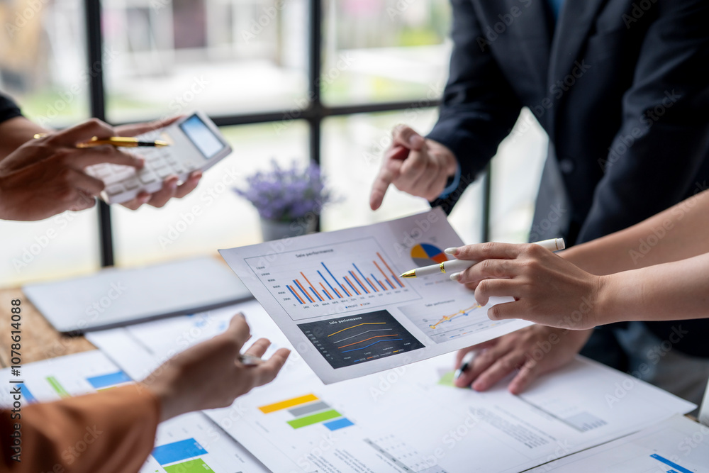 Business people working together discussing and analyzing financial charts and graphs using calculator Business people working together discussing and analyzing financial charts and graphs using calculator