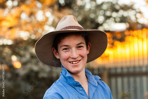 Smiling portrait of happy aussie teenager wearing akubra style hat in rural setting photo