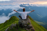 Man Meditating on Mountain Peak with Arms Outstretched, Embracing Nature and Tranquility at Sunrise Overlooking Scenic Valley
