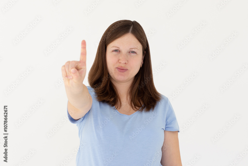 Portrait of young woman making stop sign with finger in front of the camera. Portrait of young woman making stop sign with finger in front of the camera.