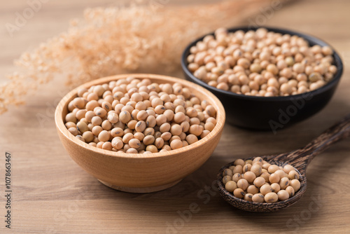 Soy bean seeds in wooden bowl with spoon on wooden background, Food ingredient