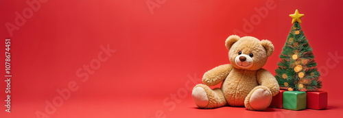 A childish Christmas banner. A teddy bear, cubes and a fir tree with lights stand on a red background. Place for the text