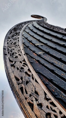 Close-up of a Viking ship replica in Tønsberg, Norway, showcasing intricate wood carvings and traditional Nordic craftsmanship. A captivating view of ancient Scandinavian culture.