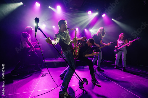 Music band playing live on stage with purple lights photo