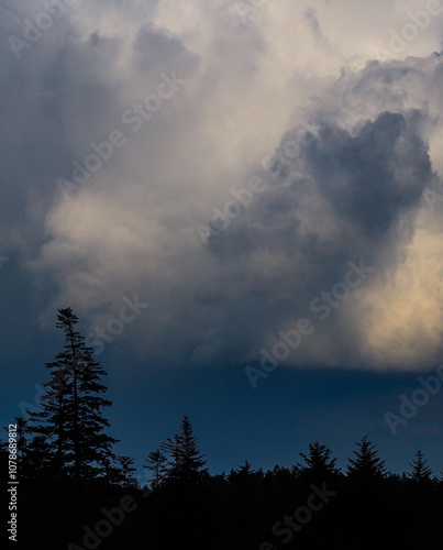 202405_Poland - Nowica, Gorlicie - dark cinematic clouds with dramatic light in bucolic countryside in the nature of Gorlicie, forests in the meadows, with the Tatras Mountains in the background