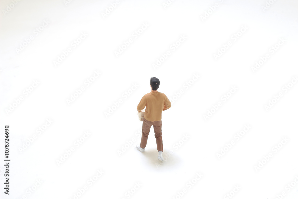 Miniature Figure Holding a Box on White Background