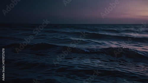 A close-up shot of the ocean at dusk with waves gently rolling.