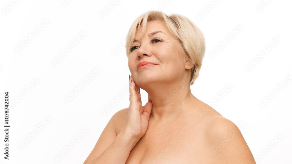 Beautiful, confident 60s woman with bared shoulders touching her soft and smooth skin against white studio background. Concept of natural beauty, spa treatment, cosmetology. Beautiful, confident 60s woman with bared shoulders touching her soft and smooth skin against white studio background. Concept of natural beauty, spa treatment, cosmetology.