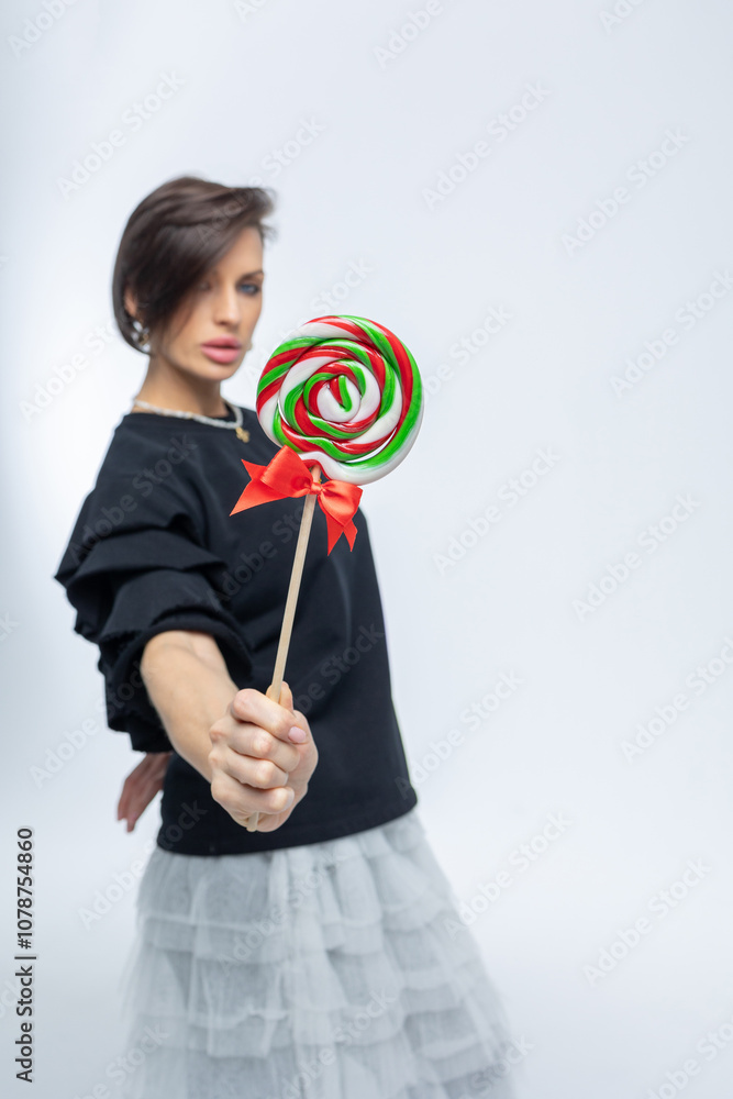 Portrait of beautiful woman with sweets round lollipop in her hand. High quality photo Portrait of beautiful woman with sweets round lollipop in her hand. High quality photo