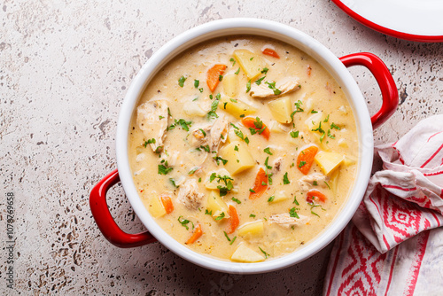 Fototapeta Chicken stew in creamy sauce with potatoes and carrots in red saucepan