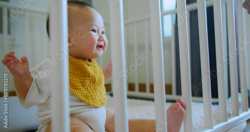Photography Cute Adorable Baby Sitting in Crib with Yellow Bib expressive face and gentle sm