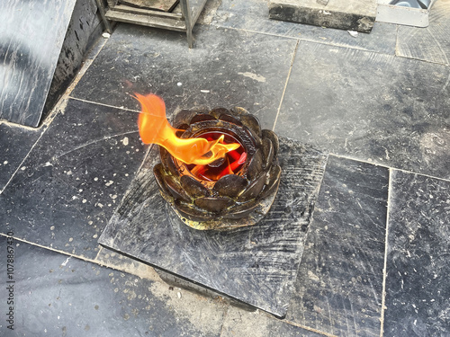 Burning incense sticks in Yonghe temple, hand with incense sticks, pilgrim lighting up his sticks from the fire, pleasant scents is one of the sensory offerings. photo