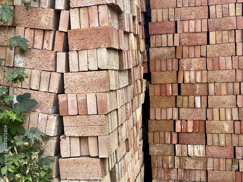 Tall stacks of red and brown clay bricks neatly arranged at a construction site, showcasing the raw materials ready for building projects and construction work. photo