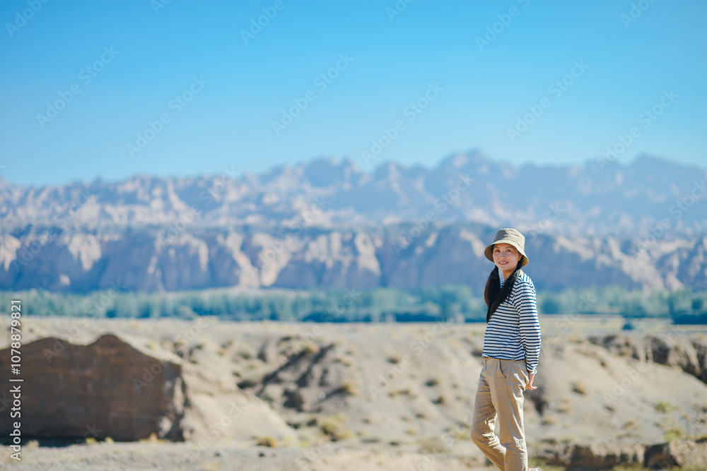 Asian female enjoying beautiful canyon landscape at Kuche Grand Canyon National Geopark, Xinjiang, China Asian female enjoying beautiful canyon landscape at Kuche Grand Canyon National Geopark, Xinjiang, China