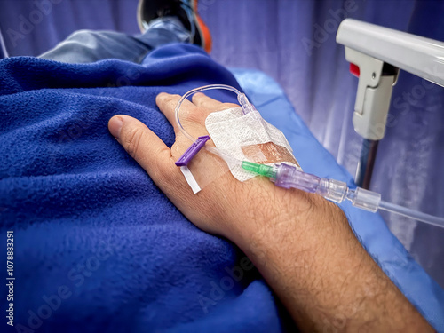 Close up view of the hand of a patient with an intravenous line that administer the drug or medicine the intravenous line photo