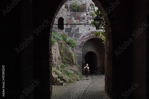 person leavaing the lipari's castle through a vaulted passage photo