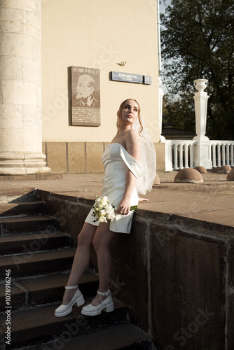 Young blonde girl is getting married. White dress and veil.
