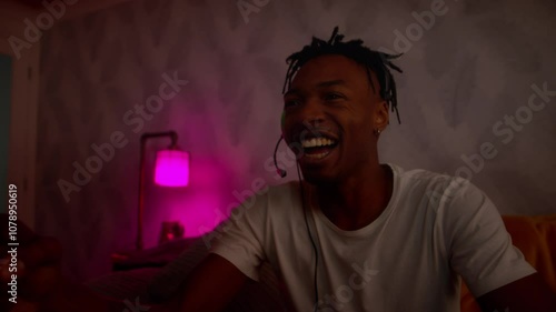 Young black male playing video games celebrates emphatically