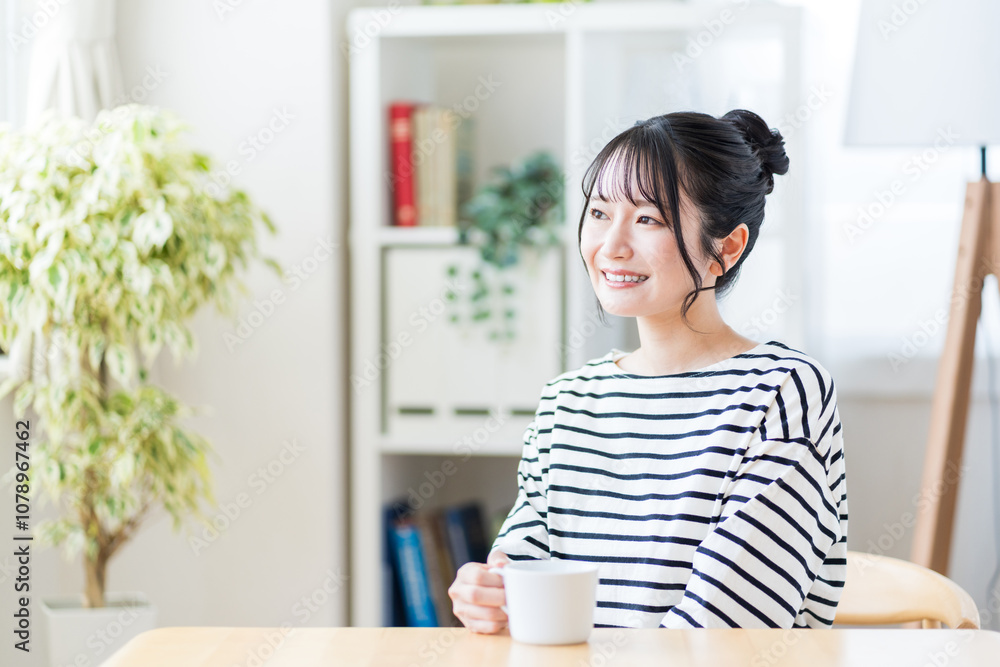 リビングでくつろぐ若い女性。
リビングでくつろぐ若い女性。