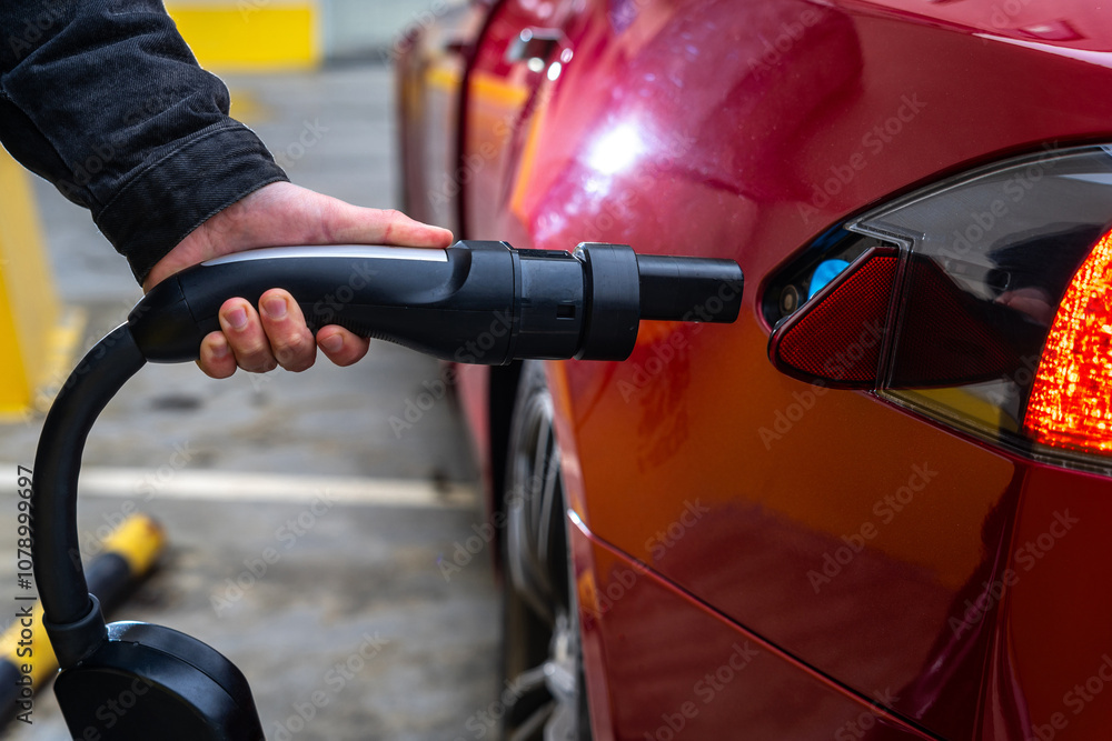 Hand Plugging Electric Car at Charging Station Hand Plugging Electric Car at Charging Station