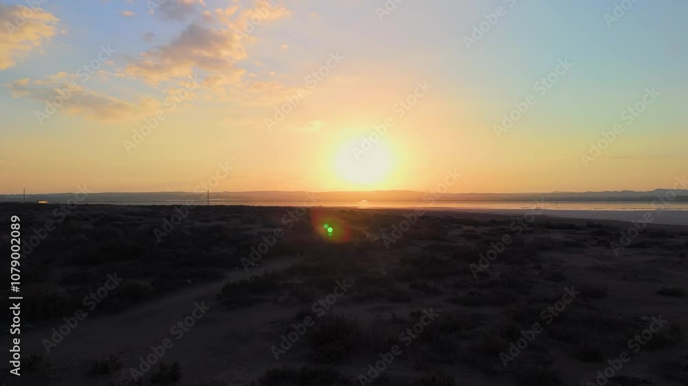 Drone View Sunrise over salt flats showcases water reflecting sunlight and clouds, creating a serene and beautiful morning scene Drone View Sunrise over salt flats showcases water reflecting sunlight and clouds, creating a serene and beautiful morning scene