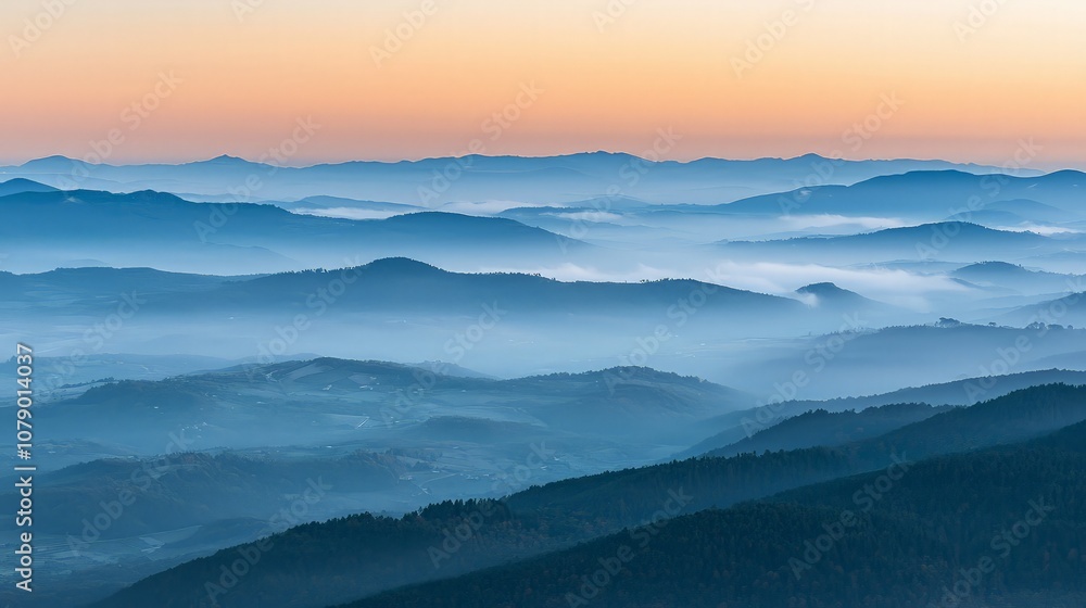 Misty mountain range at sunrise with a warm sky. Misty mountain range at sunrise with a warm sky.