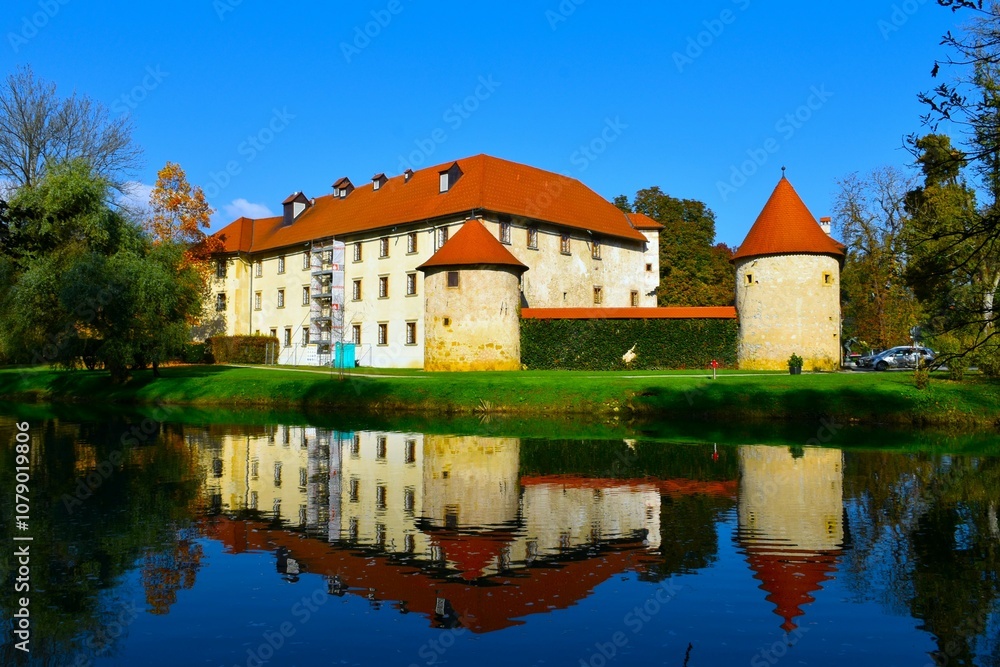 View of Otočec castle with a reflection in the water of Krka river in Dolenjska, Slovenia View of Otočec castle with a reflection in the water of Krka river in Dolenjska, Slovenia
