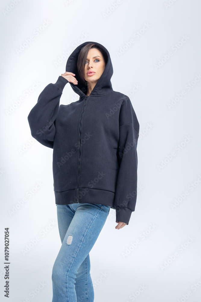 Portrait beautiful woman of model appearance. Girl in black sweatshirt on grey background. Pretty female with trendy makeup posing in studio. Vertical photo. High quality photo Portrait beautiful woman of model appearance. Girl in black sweatshirt on grey background. Pretty female with trendy makeup posing in studio. Vertical photo. High quality photo